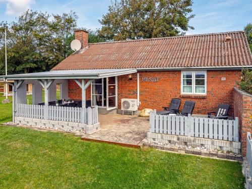 a red brick house with a white fence at Holiday Home Tuki - 700m to the fjord by Interhome in Struer