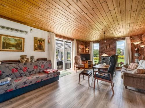 a living room with a couch and a wooden ceiling at Holiday Home Tuki - 700m to the fjord by Interhome in Struer