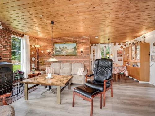 a living room with a table and a brick wall at Holiday Home Tuki - 700m to the fjord by Interhome in Struer