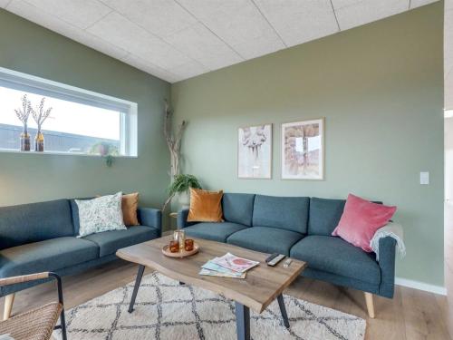 a living room with a blue couch and a table at Holiday Home Kasper - 1-8km from the sea by Interhome in Thisted