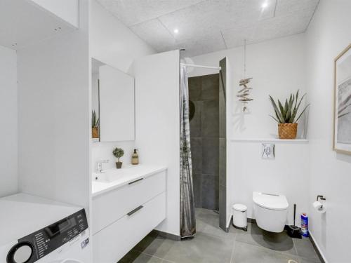 a white bathroom with a toilet and a shower at Holiday Home Kasper - 1-8km from the sea by Interhome in Thisted