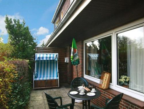 a patio with a table and chairs on a porch at Fewo 2 EG Sylt Westerland in Süderende