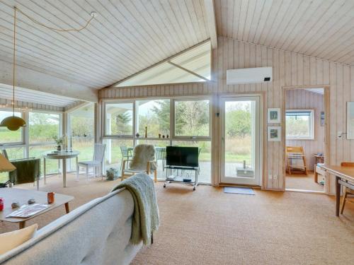 a living room with a couch and a tv at Holiday Home Aameek - 3km from the sea by Interhome in Frøstrup