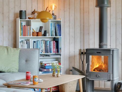 a living room with a wood stove and a table at Holiday Home Aameek - 3km from the sea by Interhome in Frøstrup