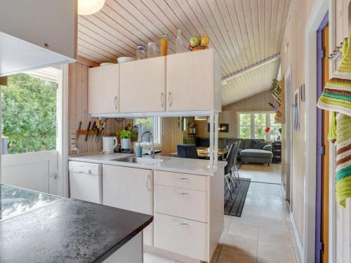 a kitchen with white cabinets and a living room at Holiday Home Dali - 400m to the fjord by Interhome in Vestervig