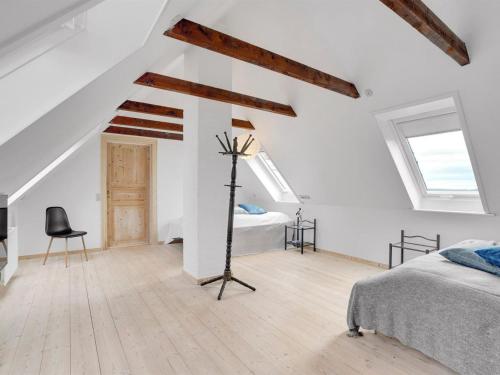 a white bedroom with a bed and a desk at Holiday Home Thorge - 75m to the inlet by Interhome in Struer