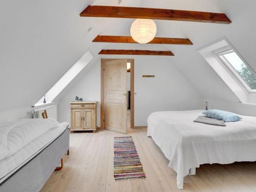 a attic bedroom with two beds and a window at Holiday Home Thorge - 75m to the inlet by Interhome in Struer