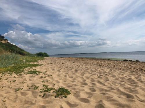 a sandy beach with a view of the ocean at Holiday Home Heera - 100m to the fjord by Interhome in Lihme