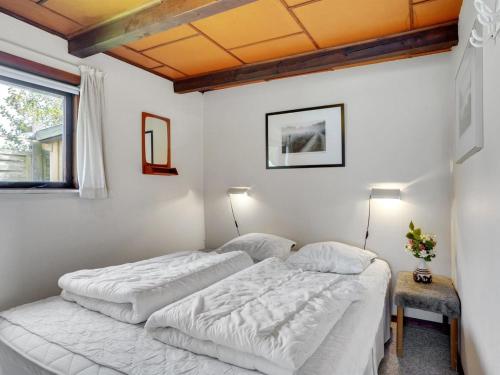 two beds in a room with white walls at Holiday Home Leocadia - 150m to the fjord by Interhome in Øsløs