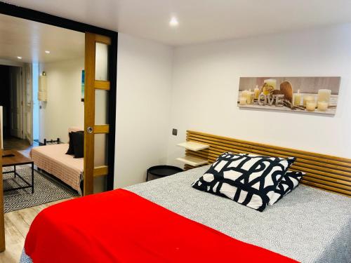 a bedroom with a red bed with a red and black pillow at Cosy Paris CDG Stade de France in Le Blanc-Mesnil