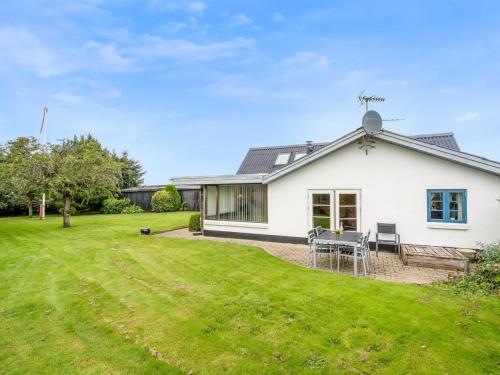a white house with a grass yard at Holiday Home Aliza - 300m to the fjord by Interhome in Roslev