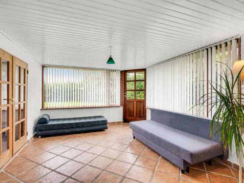 a living room with two couches and a potted plant at Holiday Home Aliza - 300m to the fjord by Interhome in Roslev