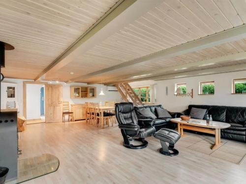 a living room with black leather furniture and a table at Holiday Home Aliza - 300m to the fjord by Interhome in Roslev