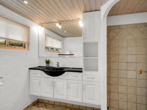 a bathroom with a sink and a shower at Holiday Home Aliza - 300m to the fjord by Interhome in Roslev