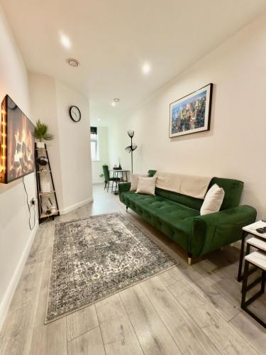 a living room with a green couch and a table at Luxe Apartment - Leicester City Centre in Leicester