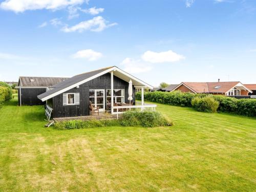 a small black house with a large yard at Holiday Home Pavo - 300m to the fjord by Interhome in Vinderup