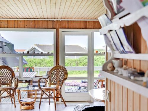 a room with chairs and a table and windows at Holiday Home Pavo - 300m to the fjord by Interhome in Vinderup