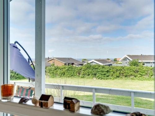 a window with a view of a field and houses at Holiday Home Pavo - 300m to the fjord by Interhome in Vinderup