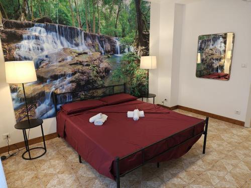 a bedroom with a bed with a waterfall painting on the wall at Tidale Host house B&B in Alghero