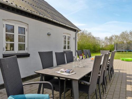a wooden table and chairs on a patio at Holiday Home Folkar - 3km to the fjord by Interhome in Thyholm
