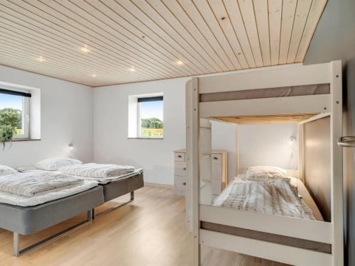 two bunk beds in a bedroom with a wooden ceiling at Holiday Home Folkar - 3km to the fjord by Interhome in Thyholm
