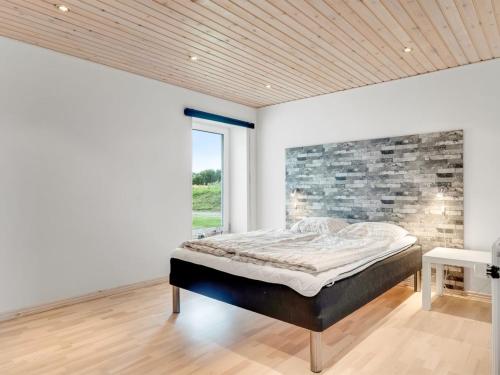 a bedroom with a bed and a brick wall at Holiday Home Folkar - 3km to the fjord by Interhome in Thyholm