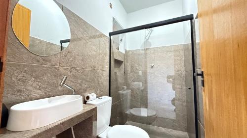 a bathroom with a toilet and a sink and a shower at Apto, em Paty do Alferes in Paty do Alferes