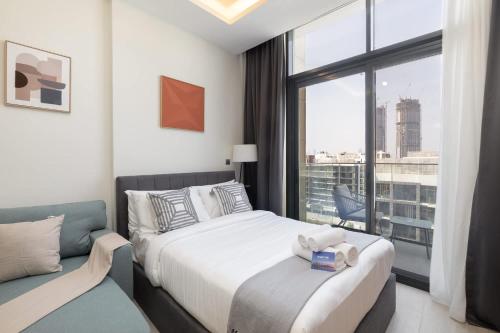 a bedroom with a bed and a large window at StayShort - Meydan Apartment sleeps 4 with a Private Balcony in Dubai
