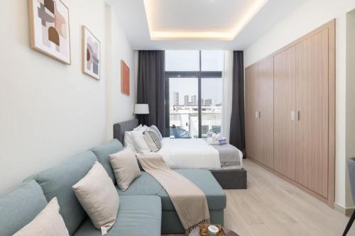 a living room with a couch and a bed at StayShort - Meydan Apartment sleeps 4 with a Private Balcony in Dubai