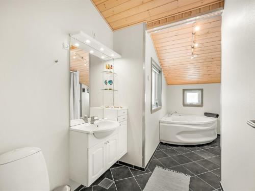 a bathroom with a sink and a tub and a toilet at Holiday Home Kai - 500m to the fjord by Interhome in Struer