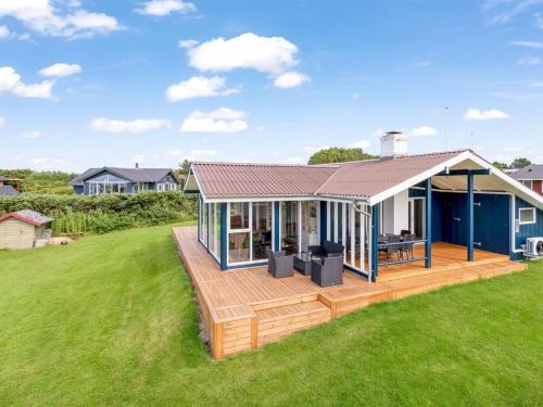 a house with a large deck on a lawn at Holiday Home Titta - 150m to the inlet by Interhome in Vinderup