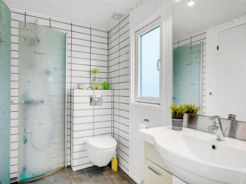 a white bathroom with a sink and a toilet at Holiday Home Titta - 150m to the inlet by Interhome in Vinderup
