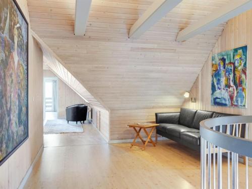 a living room with a black couch and wooden walls at Holiday Home Gertrudis - 2km to the fjord by Interhome in Frøstrup