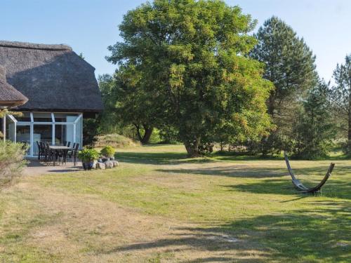 a cottage with a hammock in the yard at Holiday Home Gertrudis - 2km to the fjord by Interhome in Frøstrup