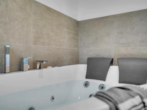 La salle de bains est pourvue d'une baignoire avec 2 chaises. dans l'établissement Holiday Home Malfred - 500m from the sea by Interhome, à Odder