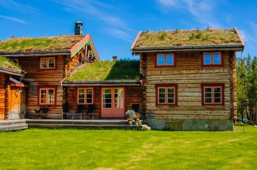 una casa di tronchi con tetto in erba di Øvre Nordli Rondane Utleie Sollia Friluftsliv a Sollia