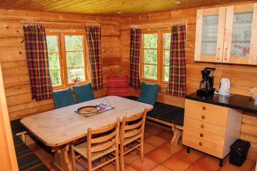 una cucina con tavolo e sedie in legno in una cabina di Øvre Nordli Rondane Utleie Sollia Friluftsliv a Sollia