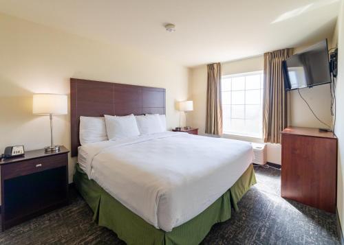 a hotel room with a large bed and a flat screen tv at Cobblestone Inn and Suites - Eaton in Eaton