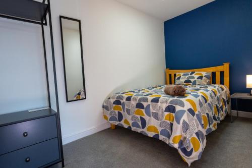 ein Schlafzimmer mit einem Bett, auf dem ein Teddybär liegt in der Unterkunft Cosy Dragons, Sherlock Holmes in Abergavenny