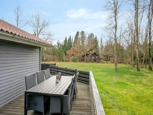 a wooden deck with a table and chairs on it at Holiday Home Anine - 200m to the fjord by Interhome in Højslev