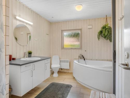 a bathroom with a tub and a toilet and a sink at Holiday Home Anine - 200m to the fjord by Interhome in Højslev