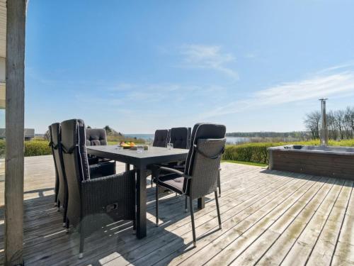 a patio with a table and chairs on a deck at Holiday Home Peetu - 200m to the fjord by Interhome in Doverodde