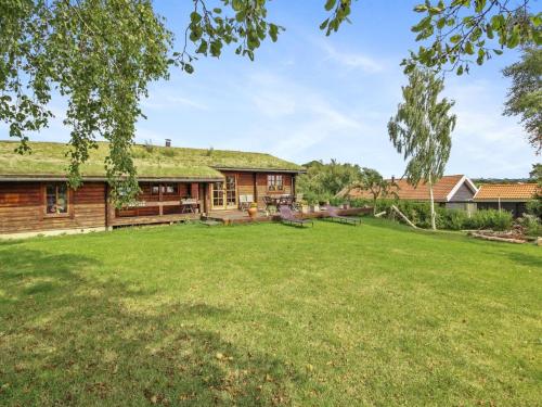 a log cabin with a grass yard at Holiday Home Kersta - 400m from the sea by Interhome in Rønde