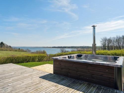 a bath tub on a deck with a view of the water at Holiday Home Peetu - 200m to the fjord by Interhome in Doverodde