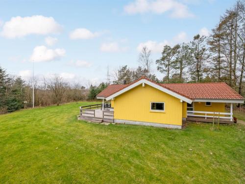a yellow house on a hill with a green field at Holiday Home Sesto - 300m to the inlet by Interhome in Højslev
