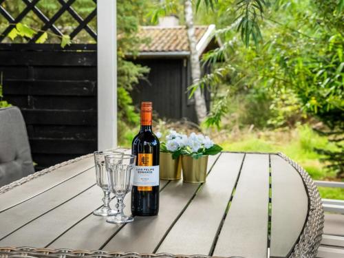 a bottle of wine sitting on a table with glasses at Holiday Home Fiallar - 7-5km from the sea by Interhome in Rønde