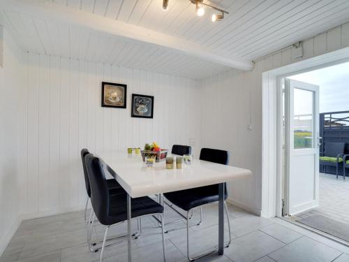 a dining room with a white table and chairs at Holiday Home Ailke - 2km to the fjord by Interhome in Thyholm