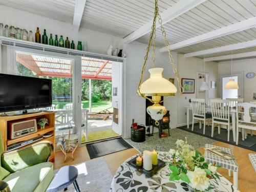 a living room with a television and a dining room at Holiday Home Deik - 2km to the fjord by Interhome in Vester Jølby