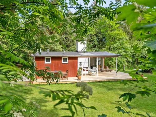 a red house with a deck in a yard at Holiday Home Deik - 2km to the fjord by Interhome in Vester Jølby