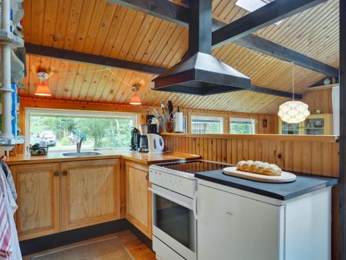 克内贝尔Holiday Home Herlek - 200m from the sea by Interhome的配有木制橱柜和炉灶烤箱的厨房